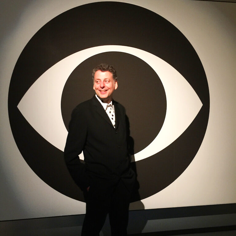 Portrait person in front of giant CBS logo