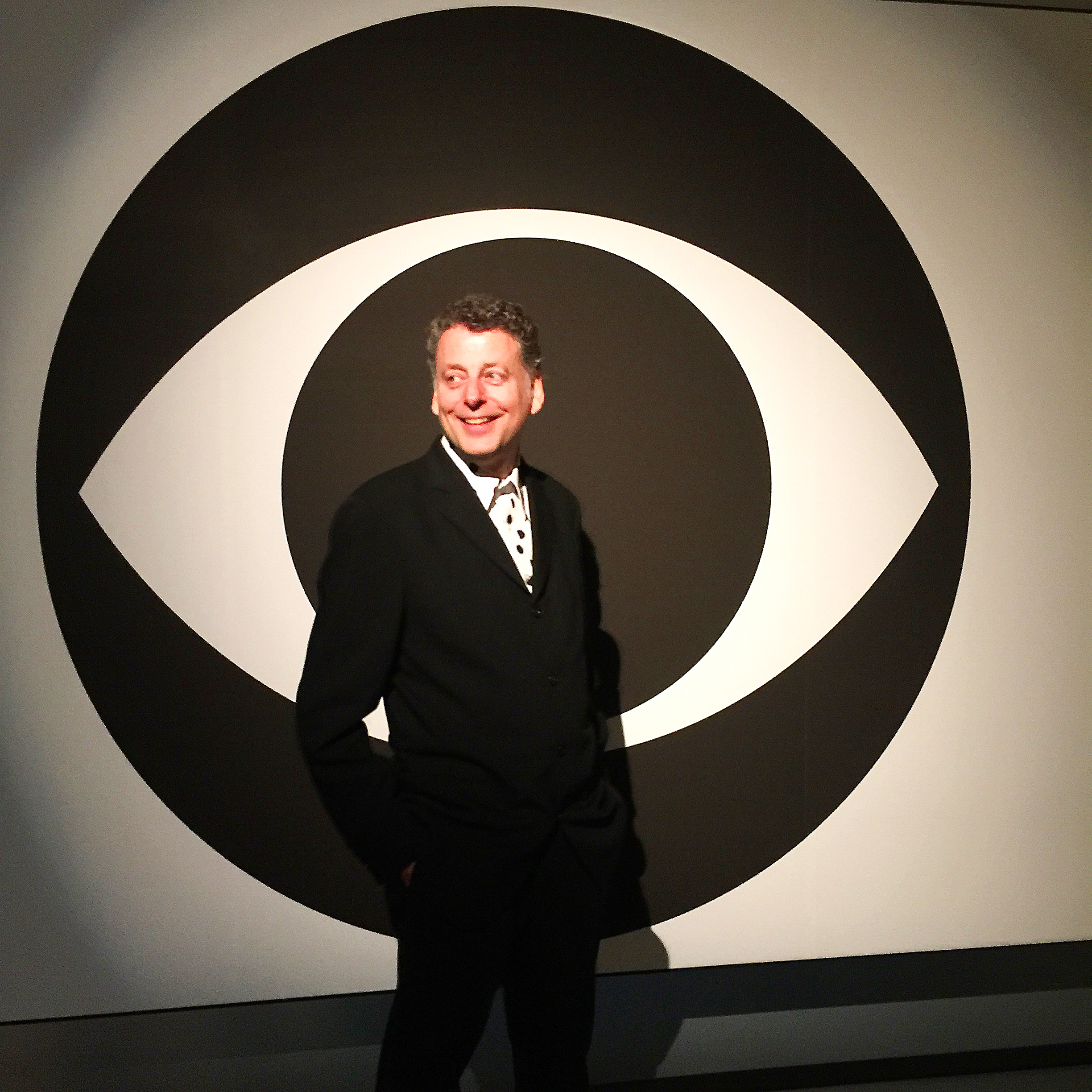 Portrait person in front of giant CBS logo